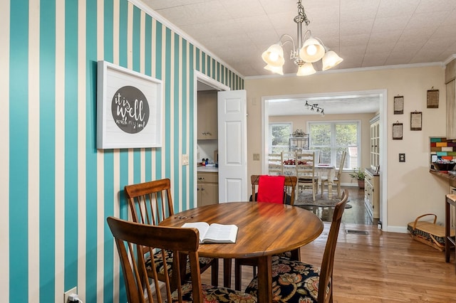 dining space featuring baseboards, crown molding, and wallpapered walls