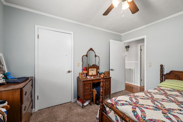 bedroom featuring ceiling fan, visible vents, crown molding, and light colored carpet