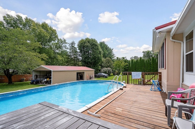 outdoor pool featuring a lawn, an outdoor structure, and a wooden deck