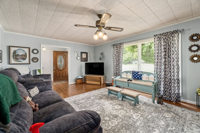 living area featuring ornamental molding, wood finished floors, and baseboards