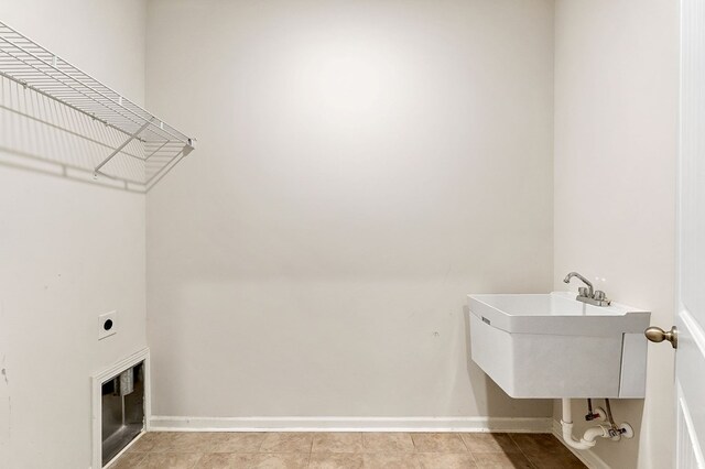 washroom with a sink, laundry area, baseboards, and electric dryer hookup