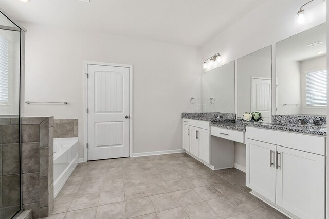 bathroom featuring baseboards, a garden tub, vanity, and tile patterned floors