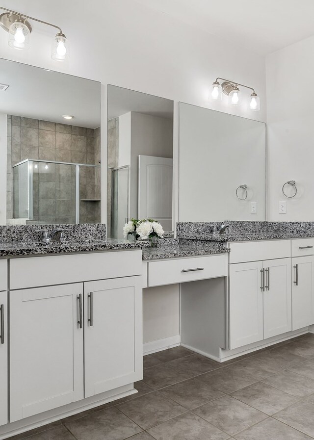 bathroom with a shower stall, vanity, and tile patterned floors