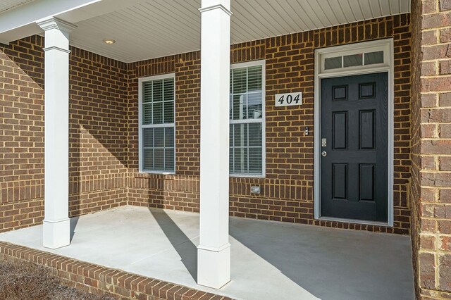 view of exterior entry featuring brick siding