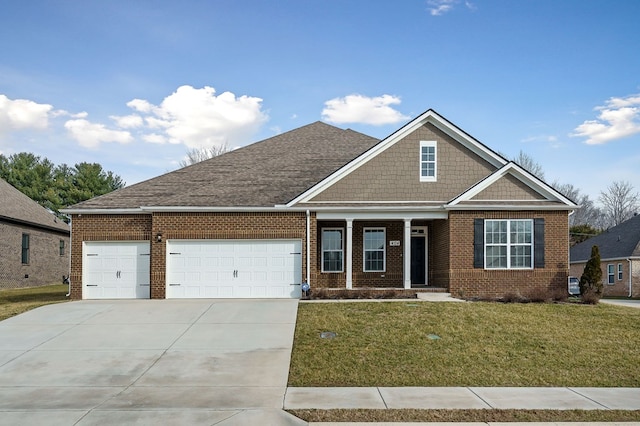 craftsman-style house featuring an attached garage, driveway, a front yard, and brick siding