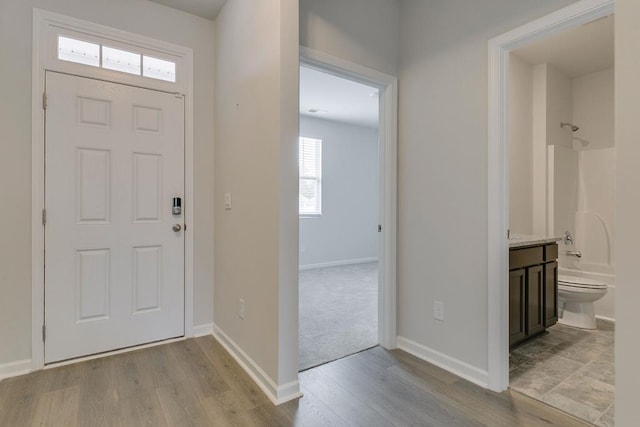 foyer entrance featuring light wood-style flooring and baseboards