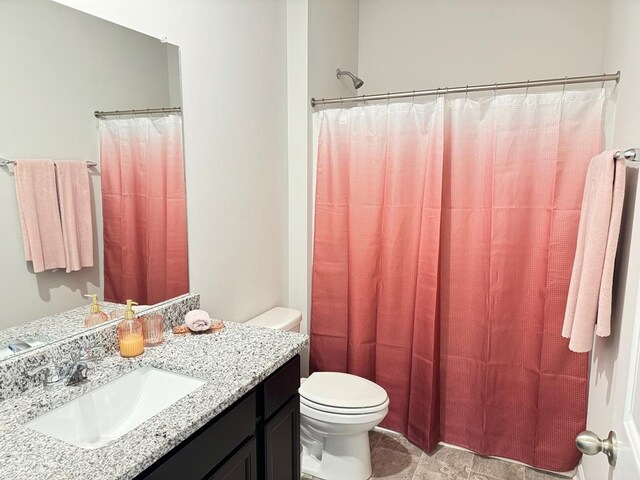 bathroom with toilet, curtained shower, and vanity