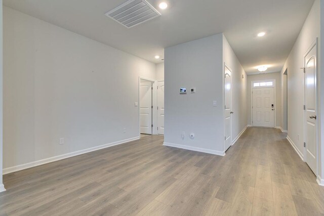 unfurnished room with light wood-type flooring, baseboards, visible vents, and recessed lighting