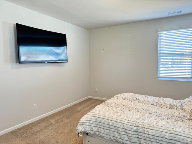 bedroom featuring light carpet, visible vents, and baseboards