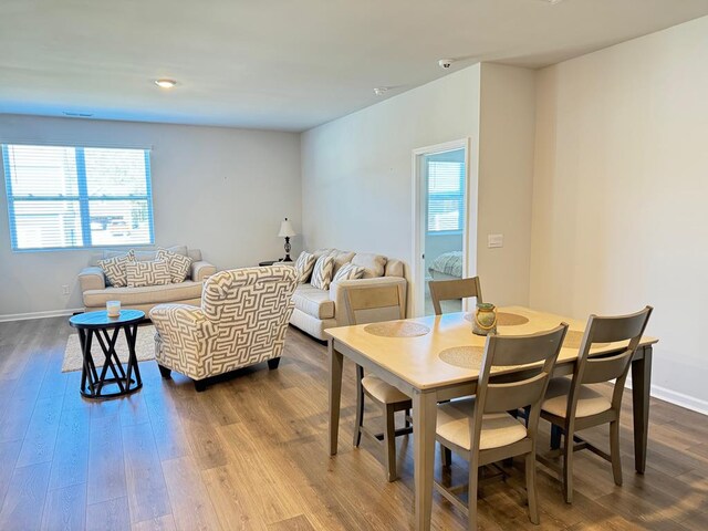 dining area with baseboards and wood finished floors