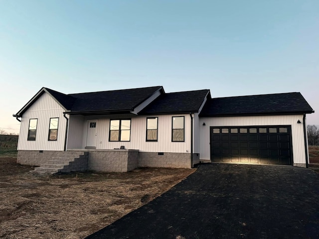 modern farmhouse style home featuring a garage, driveway, and crawl space