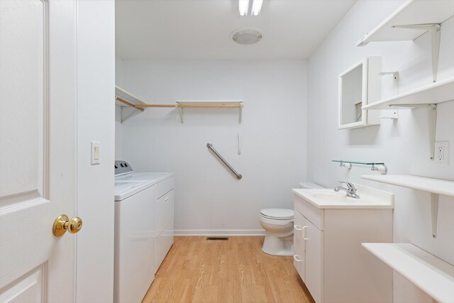 full bathroom featuring toilet, wood finished floors, visible vents, vanity, and washer and dryer