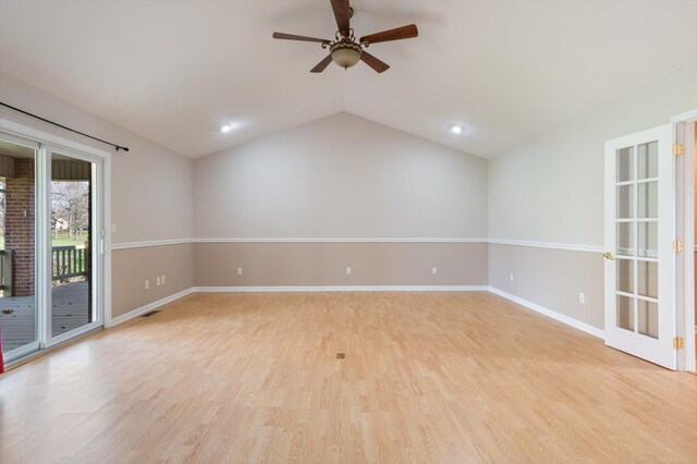 empty room featuring lofted ceiling, ceiling fan, visible vents, baseboards, and light wood-style floors