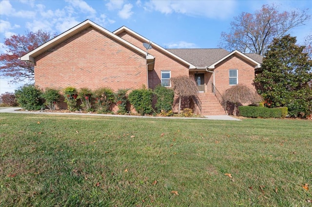 ranch-style house featuring a front lawn and brick siding