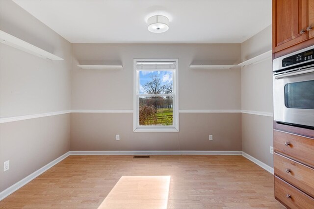 interior space with light wood-style floors, visible vents, and baseboards