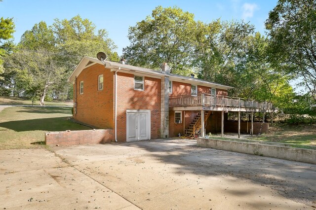 view of front of property featuring a wooden deck, stairs, and brick siding