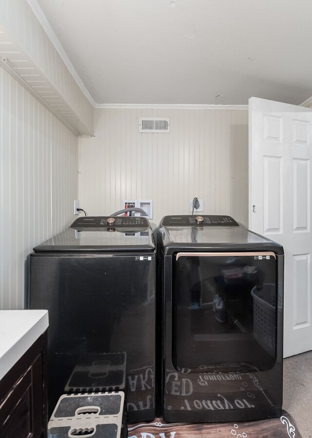 laundry area with ornamental molding, laundry area, separate washer and dryer, and visible vents