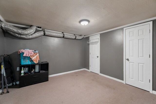 finished basement featuring carpet floors, a textured ceiling, and baseboards