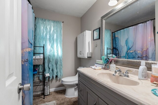 full bathroom featuring tile patterned flooring, toilet, a textured ceiling, and vanity