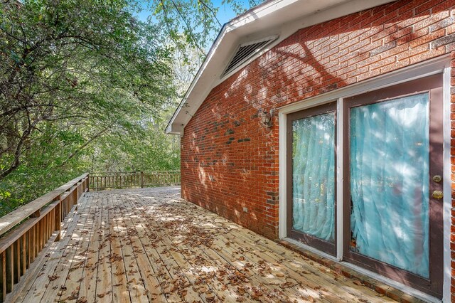 view of side of home with brick siding and a wooden deck