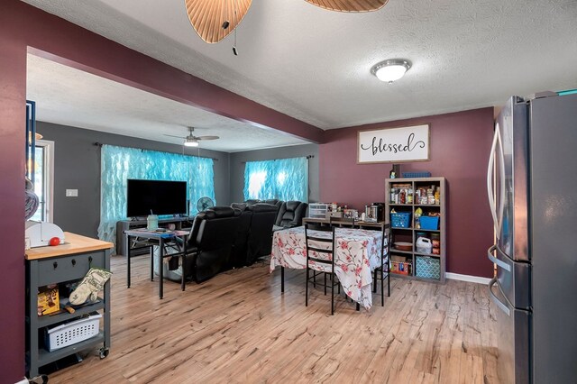 dining room with baseboards, a textured ceiling, a ceiling fan, and wood finished floors