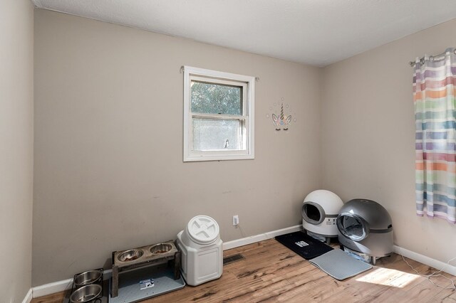 exercise room featuring light wood-type flooring and baseboards