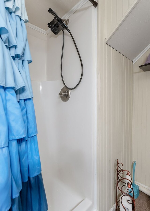 full bathroom featuring walk in shower and crown molding