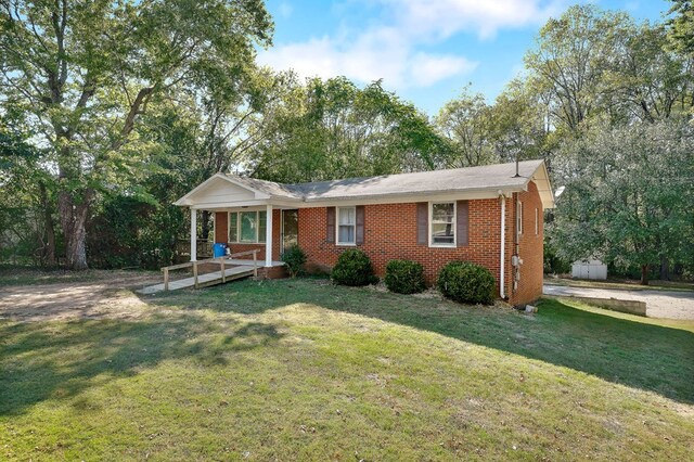 ranch-style home with a porch, brick siding, and a front lawn