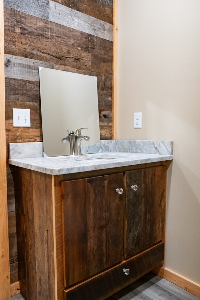 bathroom with wood finished floors, vanity, and baseboards