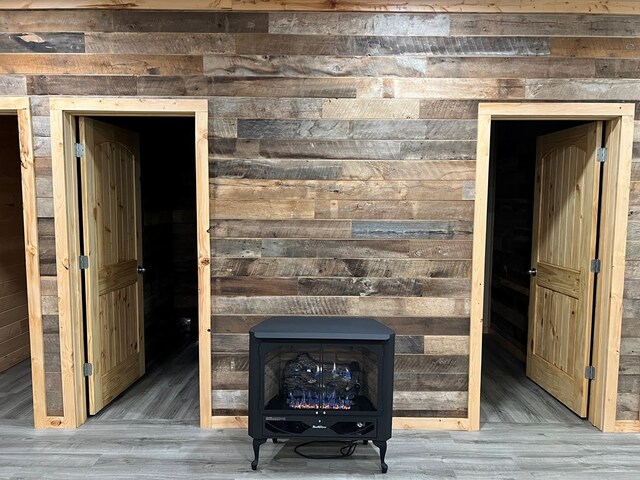 unfurnished living room featuring a wood stove and wood finished floors