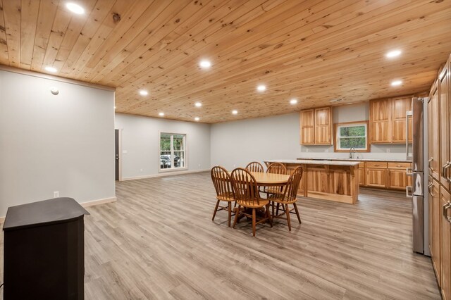 dining room with a healthy amount of sunlight, light wood-style flooring, baseboards, and recessed lighting