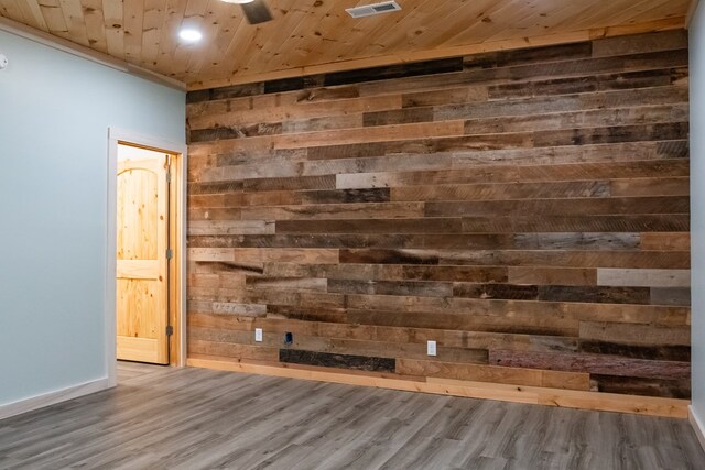 room details with wooden ceiling, wooden walls, wood finished floors, visible vents, and baseboards