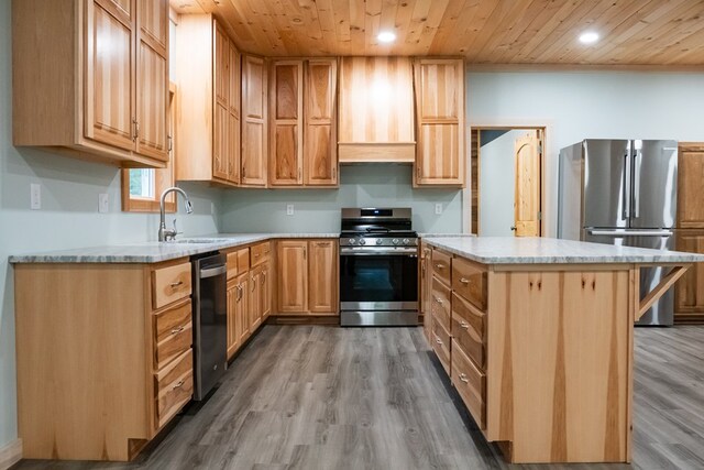 kitchen with wooden ceiling, stainless steel appliances, a sink, light countertops, and a center island