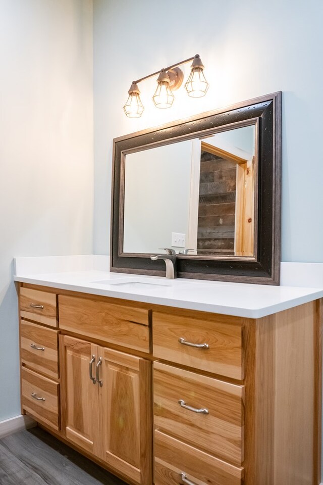 bathroom with baseboards, wood finished floors, and vanity