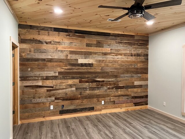 interior space with a ceiling fan, wood ceiling, wooden walls, and wood finished floors