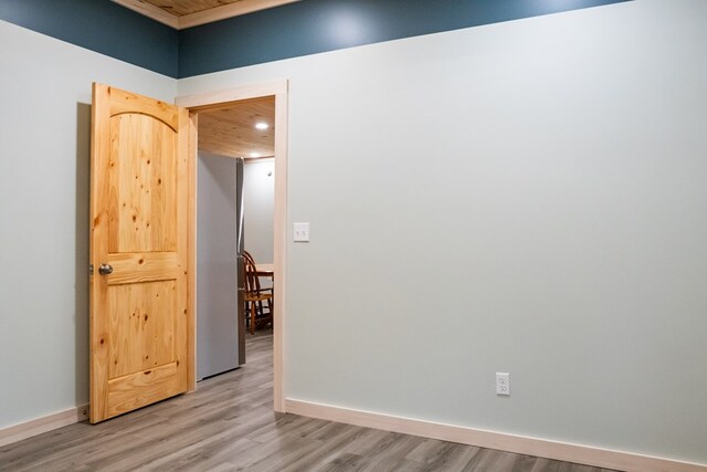 empty room featuring light wood-type flooring and baseboards