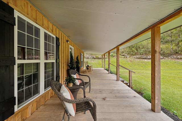 deck featuring covered porch and a yard