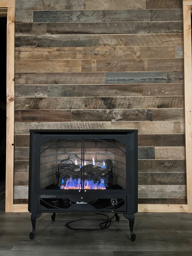 details featuring a warm lit fireplace and wood finished floors