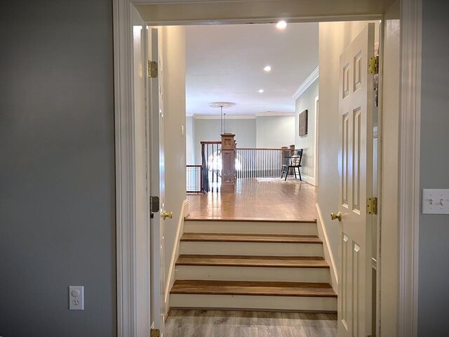 staircase with recessed lighting, crown molding, and wood finished floors