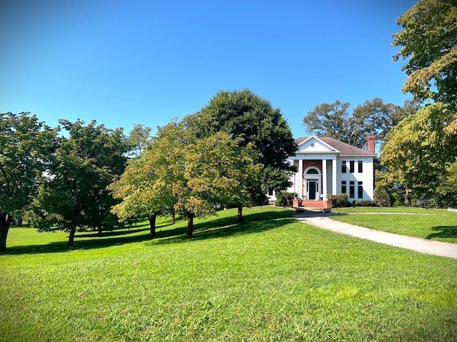 view of front of house featuring a front lawn and a chimney