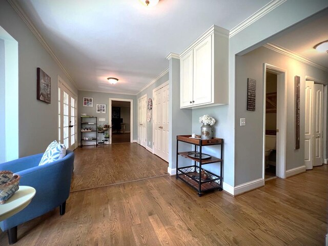 hall with crown molding, baseboards, wood finished floors, and french doors