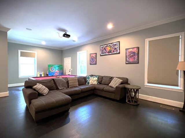 living area with ornamental molding, dark wood finished floors, and baseboards