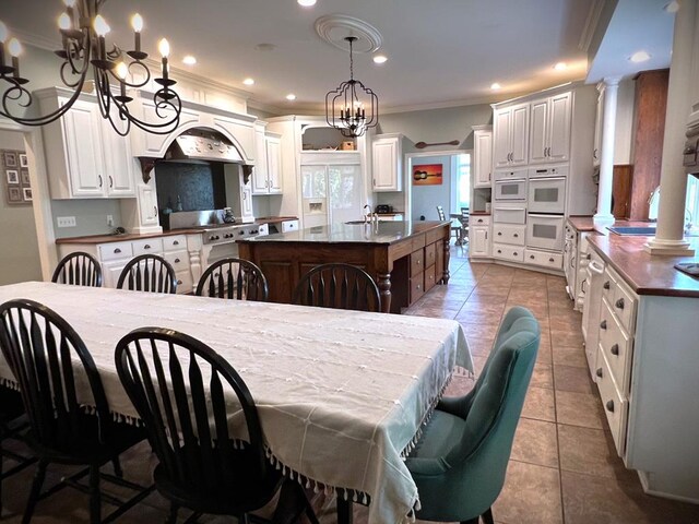 dining space featuring crown molding, a notable chandelier, decorative columns, recessed lighting, and tile patterned floors