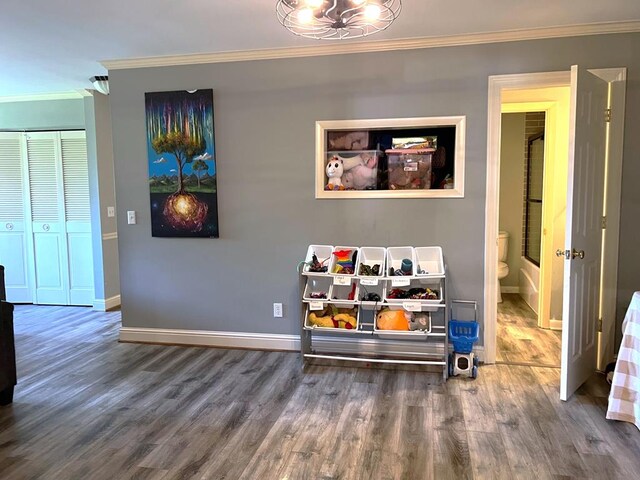 playroom with crown molding, baseboards, and wood finished floors