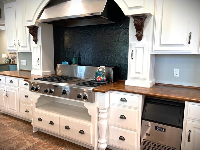 kitchen with wood counters, exhaust hood, white cabinetry, and stainless steel gas stovetop