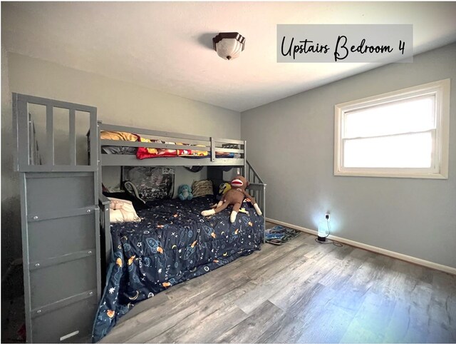 bedroom with baseboards and wood finished floors