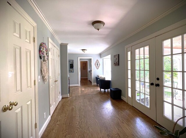 doorway with dark wood-type flooring, french doors, crown molding, and baseboards