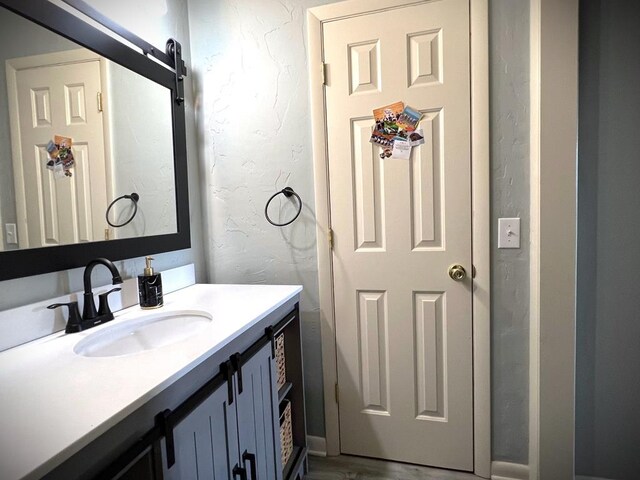 bathroom with vanity and a textured wall