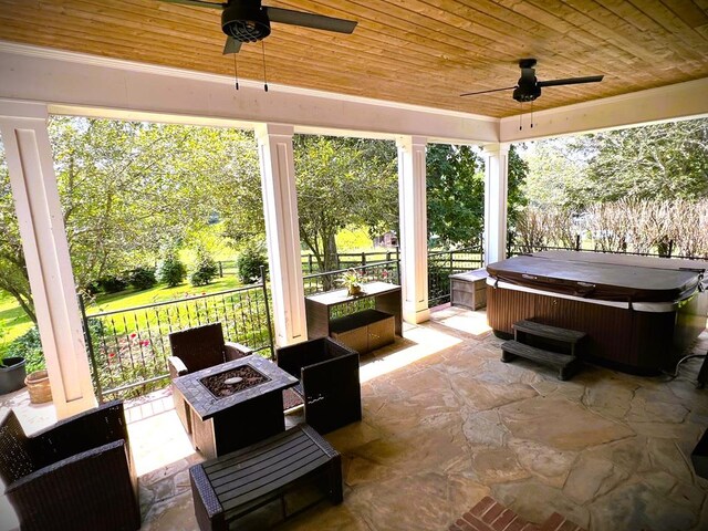 view of patio with a hot tub, a fire pit, and ceiling fan