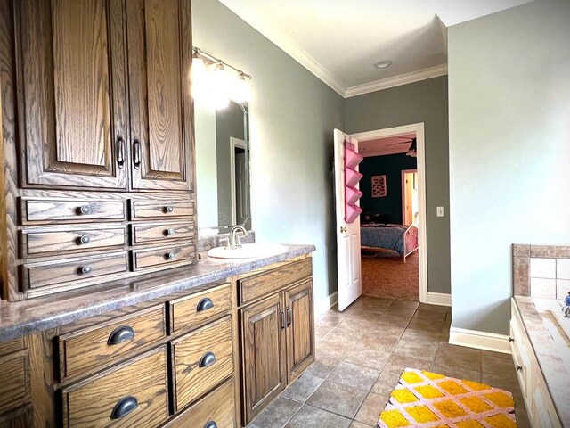 bathroom featuring a bathtub, ensuite bathroom, ornamental molding, vanity, and baseboards